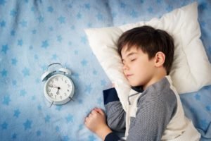 child sleeping with a clock